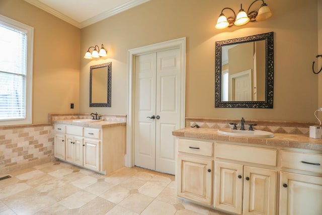 bathroom featuring a sink, two vanities, and crown molding