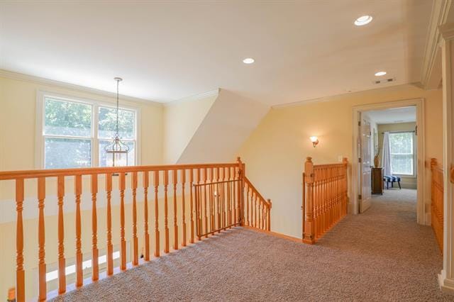 hallway with carpet, an upstairs landing, and ornamental molding