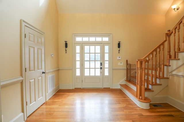 entryway featuring stairway, light wood-style flooring, and visible vents