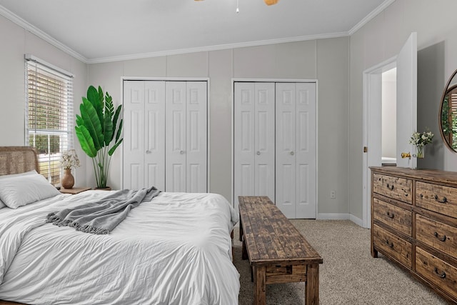 bedroom with light colored carpet, two closets, and ornamental molding