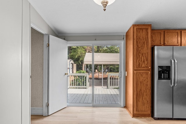 kitchen with stainless steel fridge with ice dispenser, a textured ceiling, and light hardwood / wood-style floors