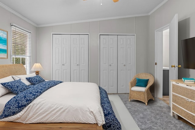 bedroom featuring crown molding and two closets