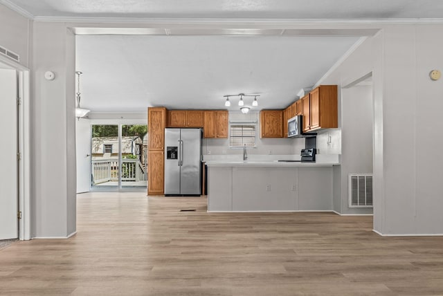 kitchen featuring kitchen peninsula, light wood-type flooring, stainless steel appliances, and ornamental molding