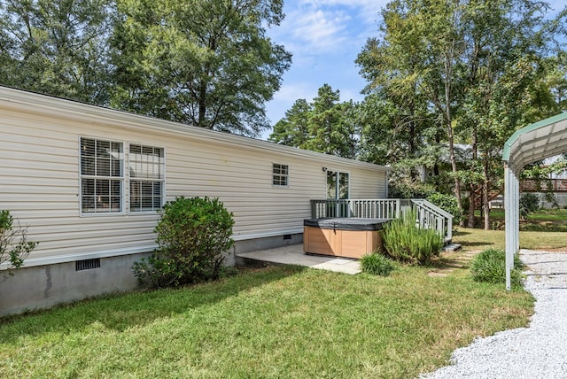 view of side of property featuring a yard and a hot tub