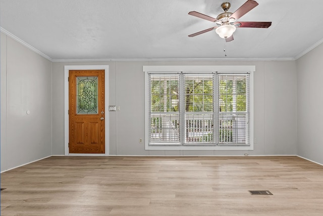 entryway with ceiling fan, light wood-type flooring, a textured ceiling, and ornamental molding