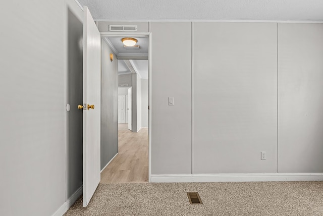 interior space featuring light colored carpet and a textured ceiling