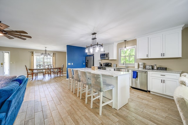 154 Old Plantation Trl, Milledgeville, GA 31061 - kitchen with appliances with stainless steel finishes, open floor plan, a chandelier, light wood-style flooring, and a sink