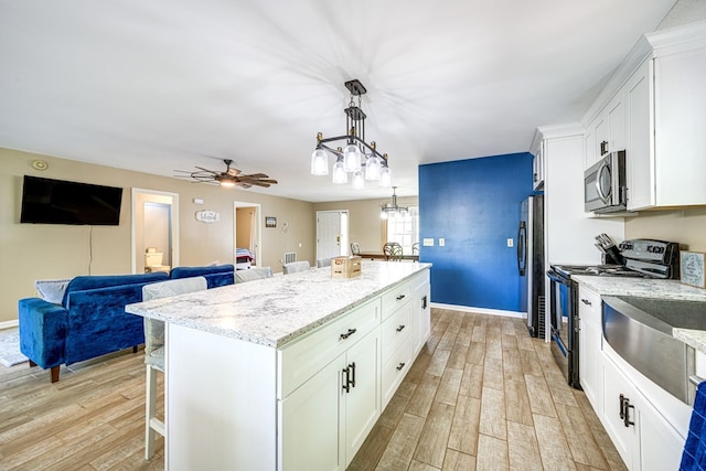 154 Old Plantation Trl, Milledgeville, GA 31061 - kitchen with stainless steel appliances, a breakfast bar, a center island, open floor plan, and light wood-type flooring
