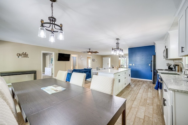 154 Old Plantation Trl, Milledgeville, GA 31061 - dining space featuring a chandelier, a ceiling fan, light wood finished floors, and baseboards