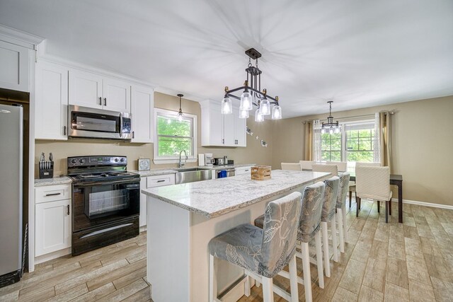 154 Old Plantation Trl, Milledgeville, GA 31061 - kitchen with appliances with stainless steel finishes, light wood-type flooring, a center island, and healthy amount of natural light