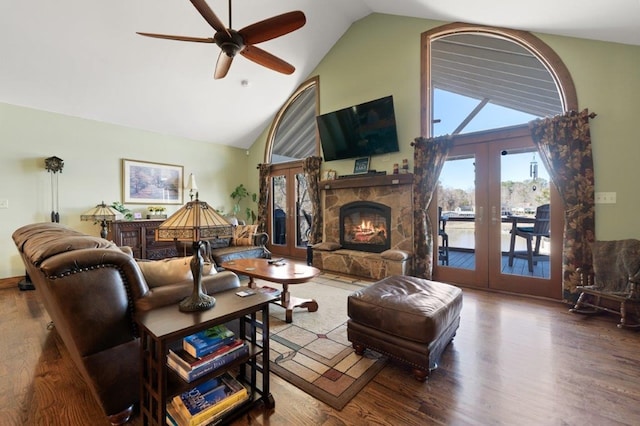 living room with french doors, high vaulted ceiling, ceiling fan, a fireplace, and hardwood / wood-style floors