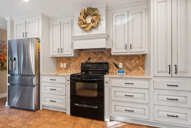 kitchen with black range with electric stovetop, white cabinetry, light stone countertops, tasteful backsplash, and stainless steel fridge