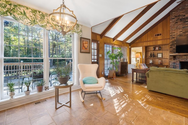 sitting room with built in features, high vaulted ceiling, a chandelier, wooden walls, and a fireplace