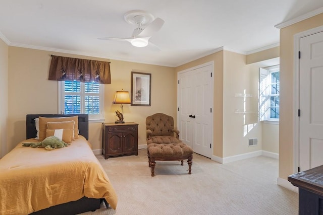 bedroom featuring ceiling fan, a closet, light colored carpet, and ornamental molding