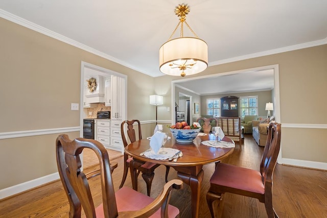 dining space featuring a chandelier, hardwood / wood-style flooring, and ornamental molding