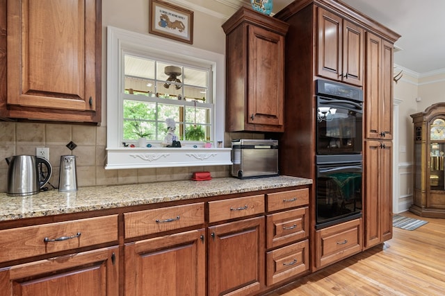 411 Rockville Rd, Eatonton, GA 31024 - kitchen featuring crown molding, light stone counters, decorative backsplash, light wood finished floors, and brown cabinets