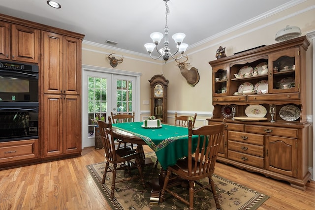 411 Rockville Rd, Eatonton, GA 31024 - dining space with crown molding, a chandelier, wainscoting, light wood-type flooring, and french doors