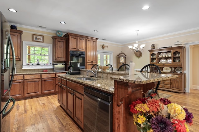 411 Rockville Rd, Eatonton, GA 31024 - kitchen featuring appliances with stainless steel finishes, light wood finished floors, a breakfast bar area, a kitchen island with sink, and decorative light fixtures