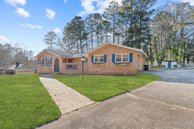 ranch-style house with a garage and a front lawn