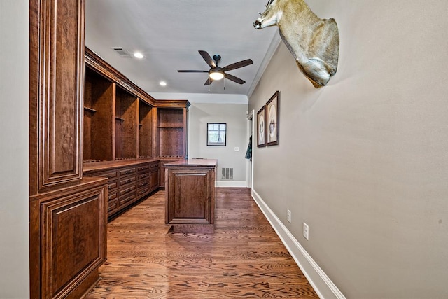 unfurnished office with crown molding, dark hardwood / wood-style flooring, and ceiling fan