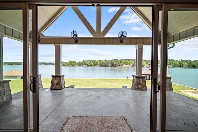 exterior space with plenty of natural light, vaulted ceiling, a water view, and concrete floors