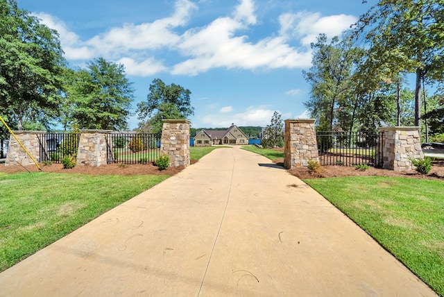view of gate with a lawn
