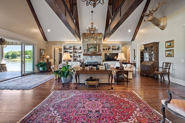 living room with a fireplace, built in shelves, dark hardwood / wood-style floors, and high vaulted ceiling