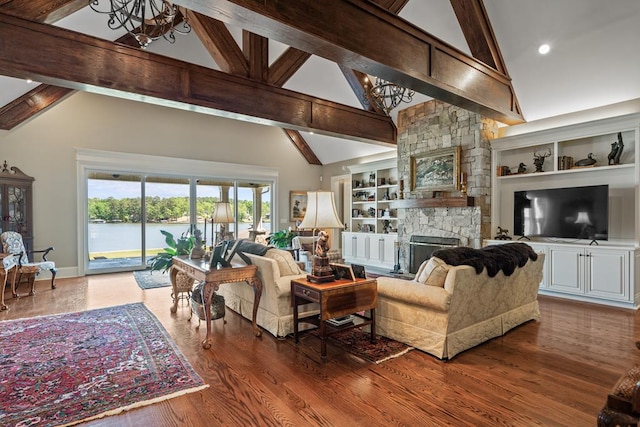 living room with a fireplace, built in shelves, high vaulted ceiling, and beamed ceiling