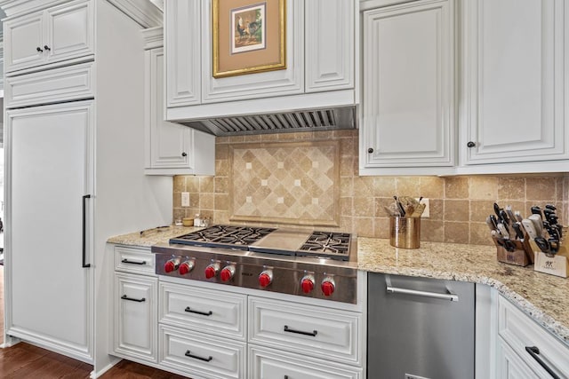 kitchen featuring stainless steel gas stovetop, light stone countertops, white cabinetry, and decorative backsplash