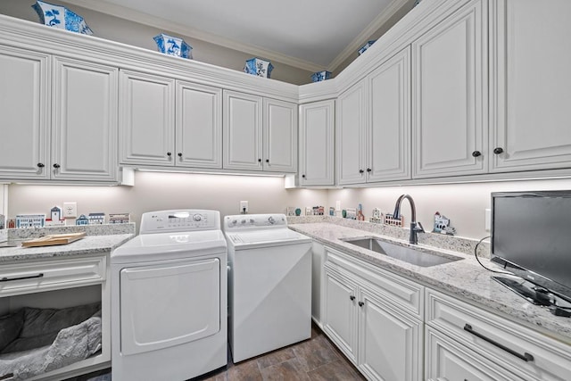 laundry area featuring cabinets, washing machine and dryer, ornamental molding, and sink