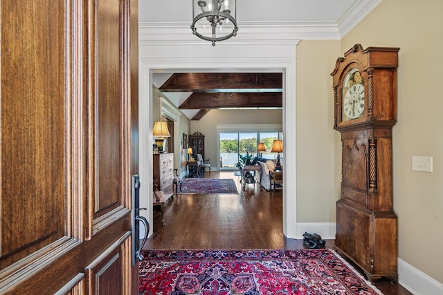 foyer entrance with a chandelier, vaulted ceiling with beams, hardwood / wood-style flooring, and ornamental molding