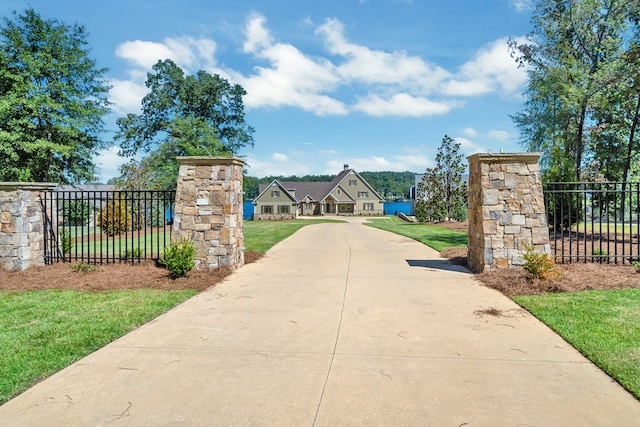 view of gate with a lawn