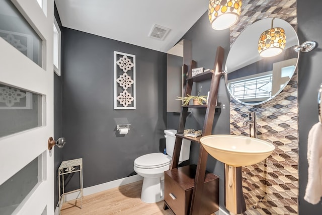 bathroom featuring hardwood / wood-style flooring and toilet