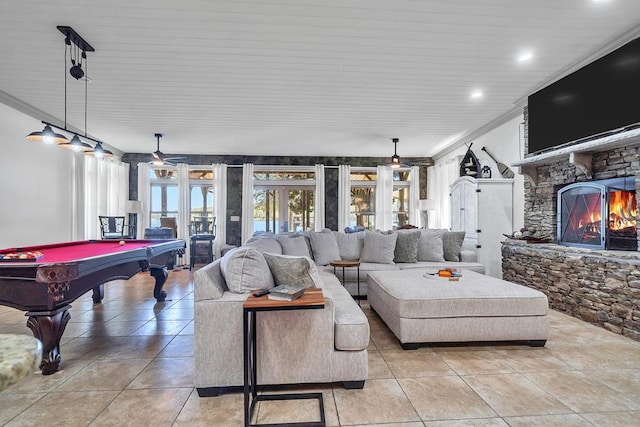 living room with french doors, a stone fireplace, ornamental molding, and pool table