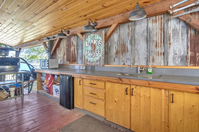 kitchen with hardwood / wood-style floors, black fridge, sink, and wood ceiling