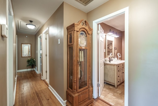 220 Pitts Chapel Rd, Newborn, GA 30056 - corridor featuring attic access, light wood-style flooring, baseboards, and a sink