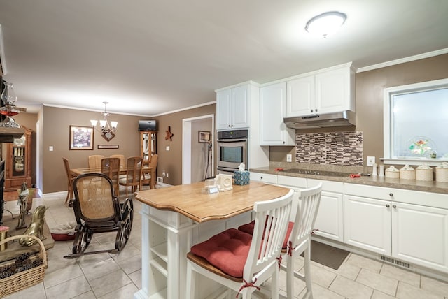 220 Pitts Chapel Rd, Newborn, GA 30056 - kitchen with black electric cooktop, under cabinet range hood, visible vents, light tile patterned floors, and stainless steel oven