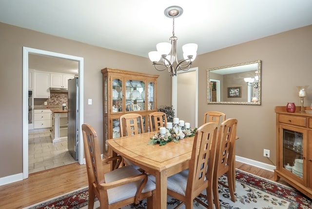 220 Pitts Chapel Rd, Newborn, GA 30056 - dining room with light wood finished floors, baseboards, and a chandelier