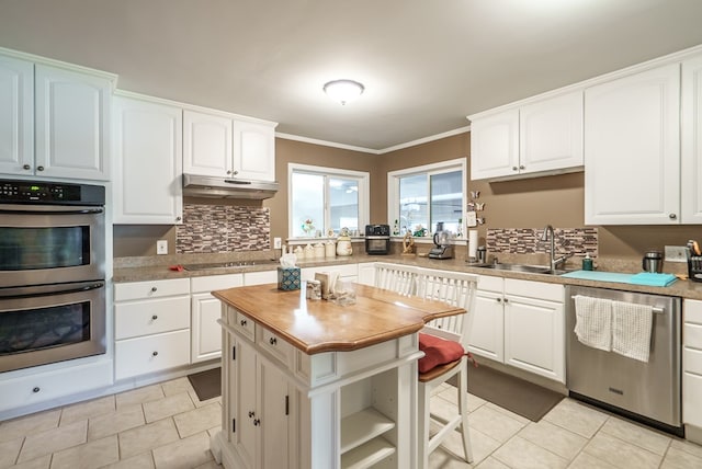 220 Pitts Chapel Rd, Newborn, GA 30056 - kitchen with stainless steel appliances, a sink, backsplash, under cabinet range hood, and wooden counters
