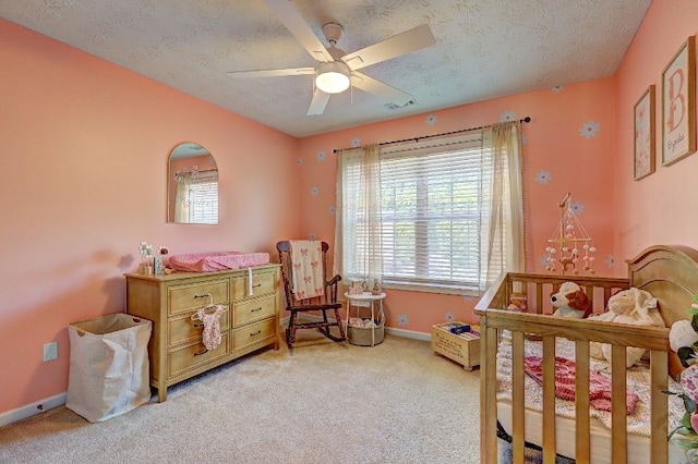 bedroom with ceiling fan, light colored carpet, a textured ceiling, baseboards, and visible vents