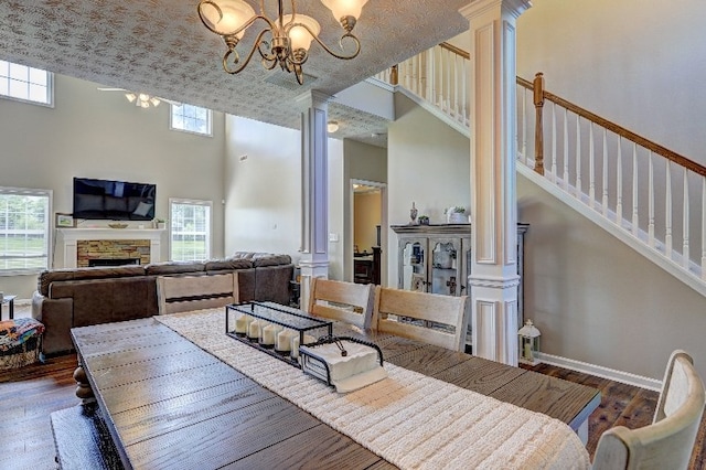 dining room with decorative columns, a towering ceiling, and a notable chandelier