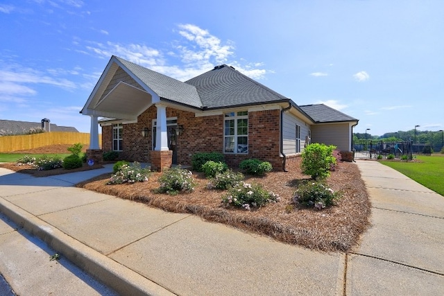 view of side of property with fence and brick siding