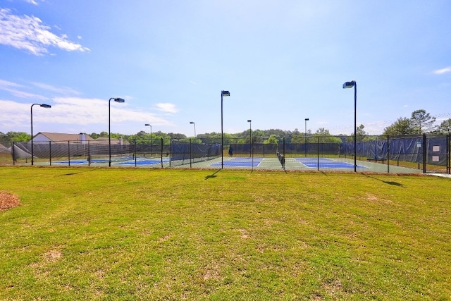 view of sport court with a lawn, fence, and community basketball court
