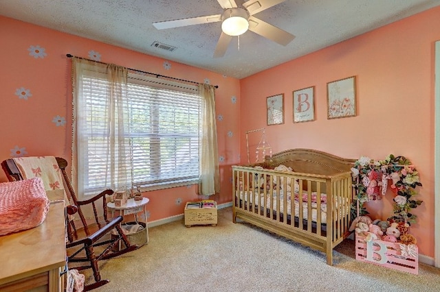 carpeted bedroom featuring baseboards, a ceiling fan, a textured ceiling, and visible vents