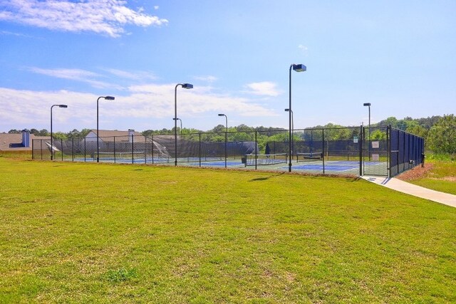 view of sport court featuring a lawn and fence
