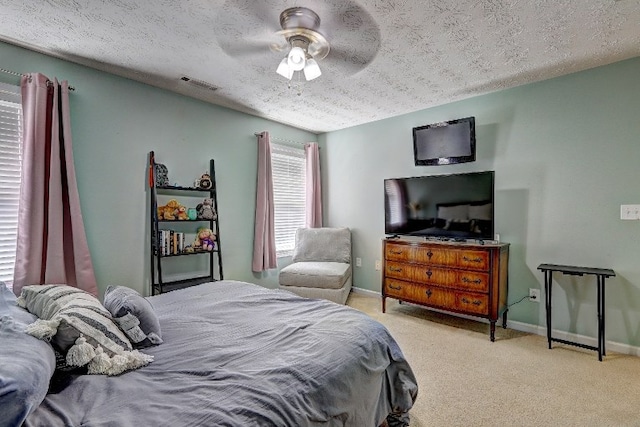 carpeted bedroom featuring visible vents, a textured ceiling, and baseboards