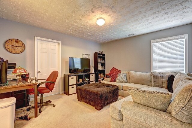 living room with visible vents, carpet flooring, and a textured ceiling