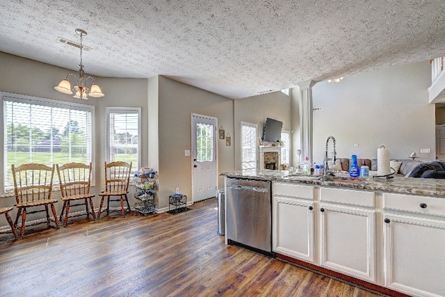 kitchen featuring dark wood-style flooring, visible vents, dishwasher, a sink, and an inviting chandelier