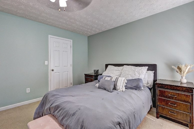 bedroom featuring a ceiling fan, a textured ceiling, baseboards, and carpet