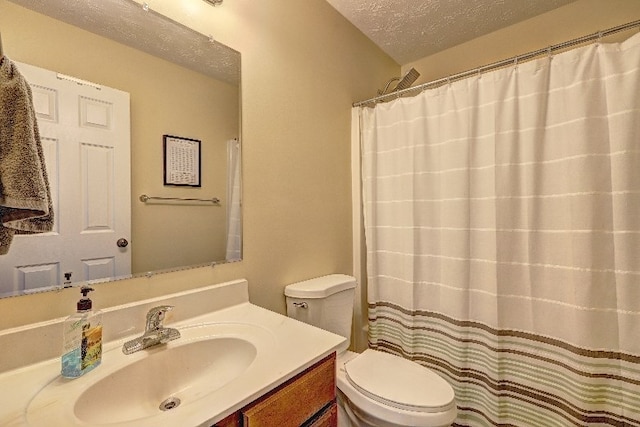 bathroom featuring vanity, toilet, and a textured ceiling